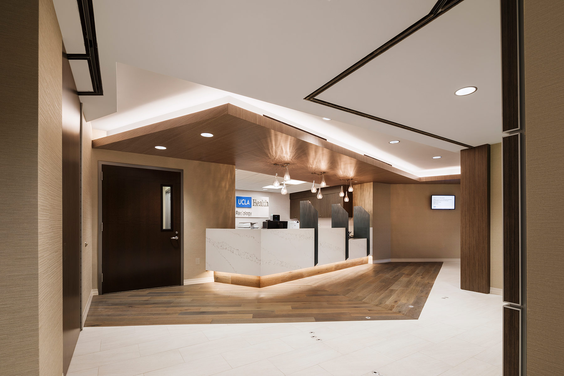 The lobby and reception area of a modern healthcare center in LA County, transformed by KARDENT interior design architects.